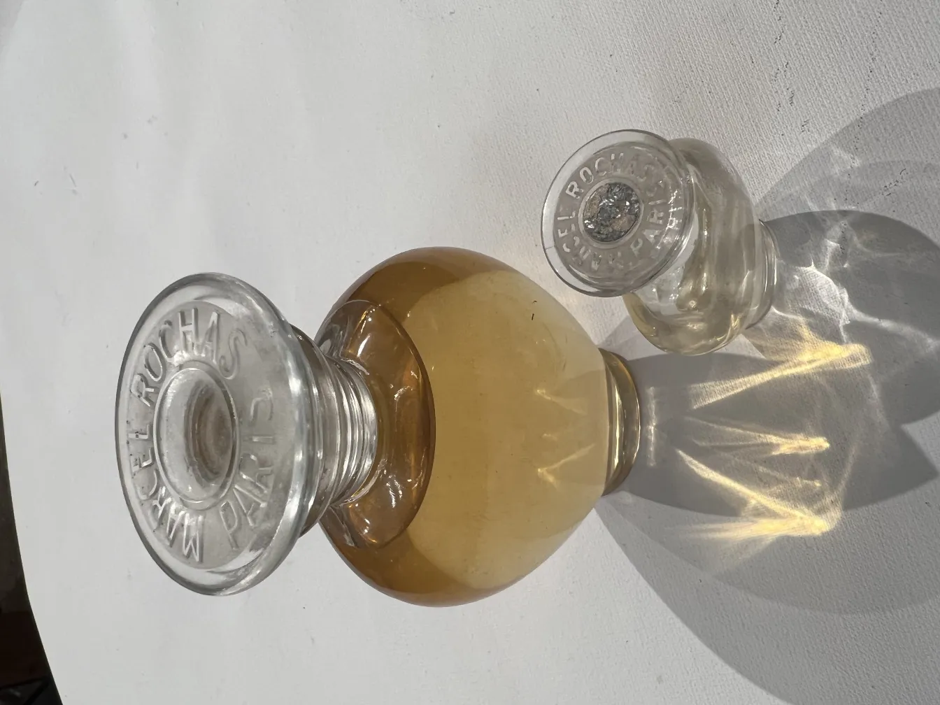 flacon ancien de parfum avec bouchon décoratif et liquide doré