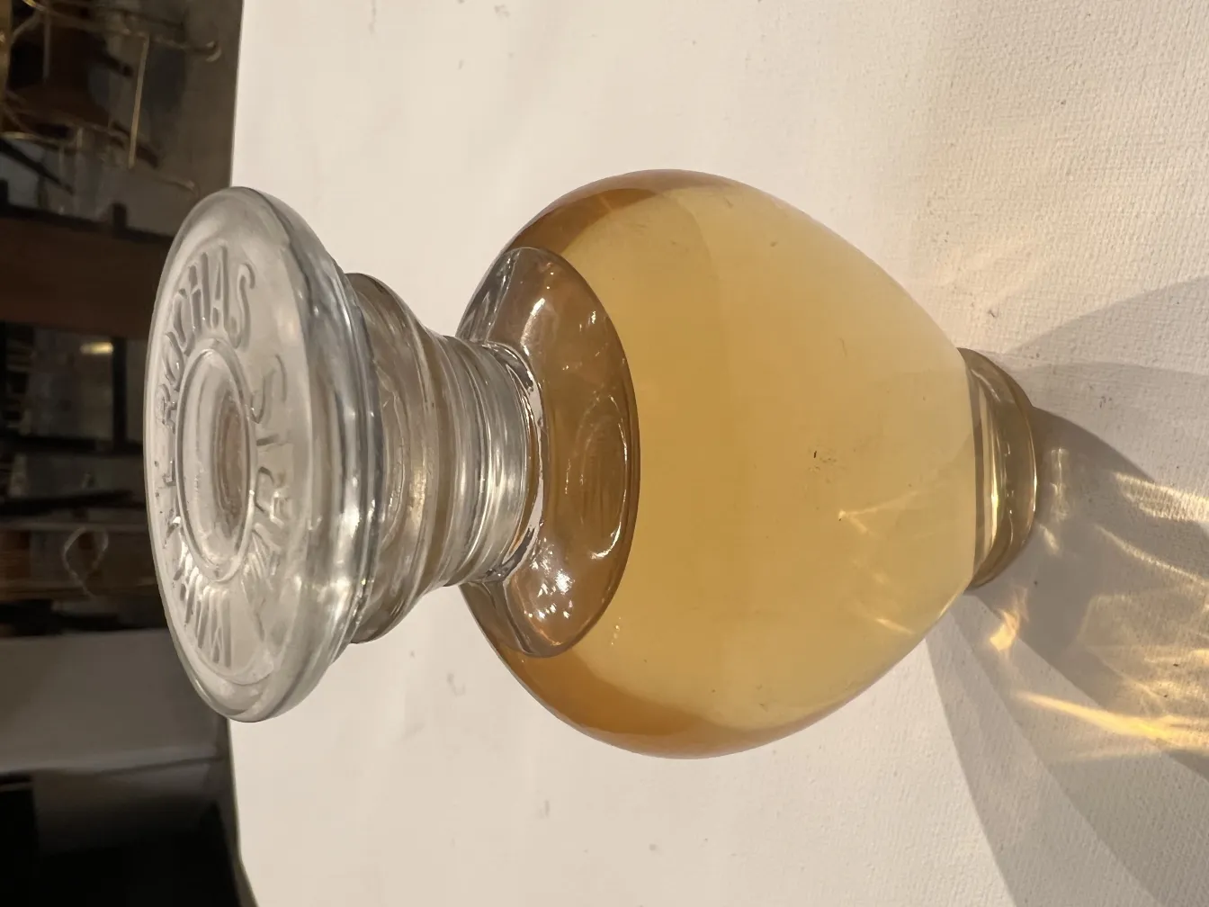 flacon de parfum ancien avec capuchon en verre clair et liquide doré