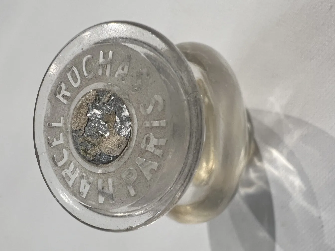 Frasco de perfume antigo da marca Rochas com rotulo distintivo na base.