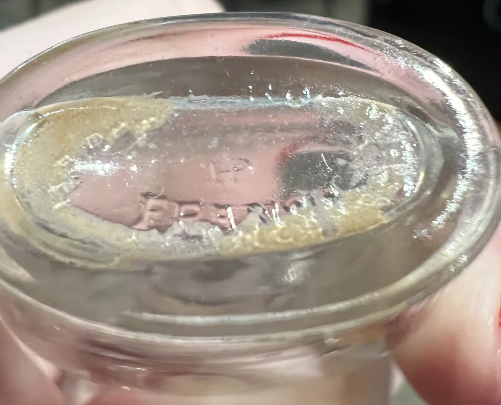 Старинный флакон для духов с элегантным дизайном, видимые детали снизу.