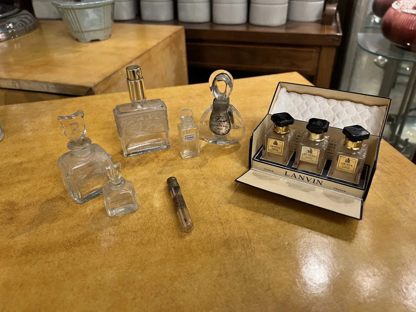 いくつかの古い香水瓶が明るい木の表面に装飾的に配置されています。