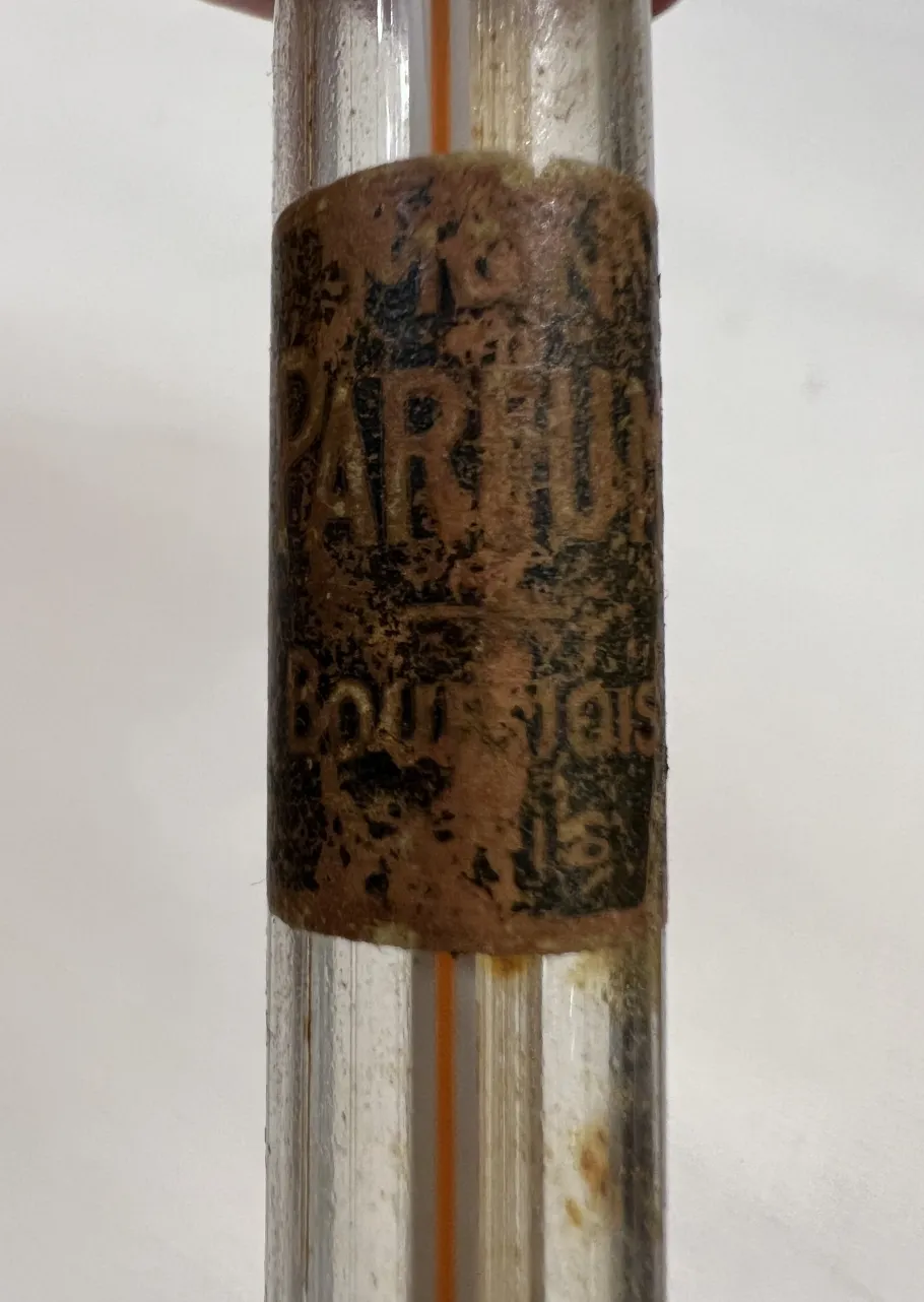 flacon de parfum ancien avec étiquette abîmée et poussière