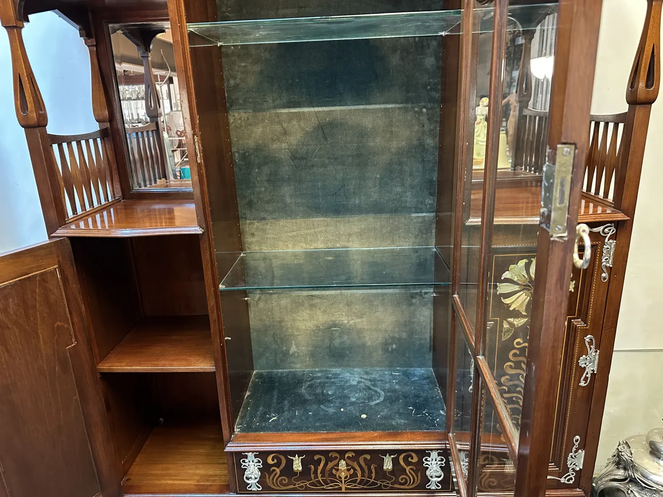 Antique display cabinet with glass shelves and floral decor