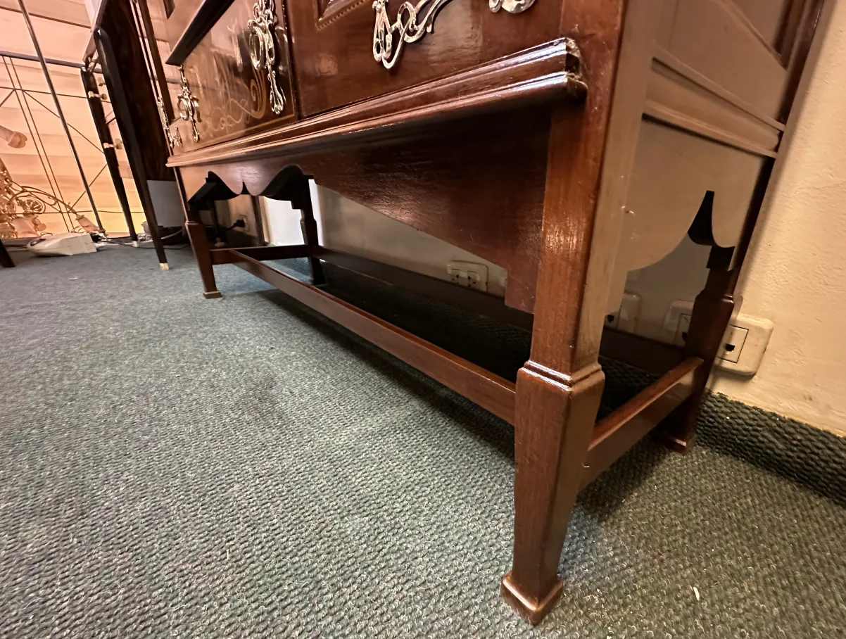 vitrina antigua con decoración elaborada y patas esculpidas, exhibiendo objetos