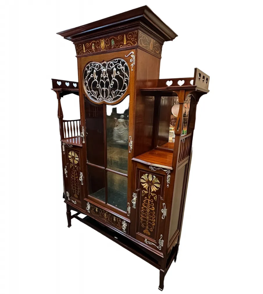 Vetrina antica con scaffali decorativi e dettagli elaborati, perfetta per esporre oggetti unici in un ambiente accogliente.