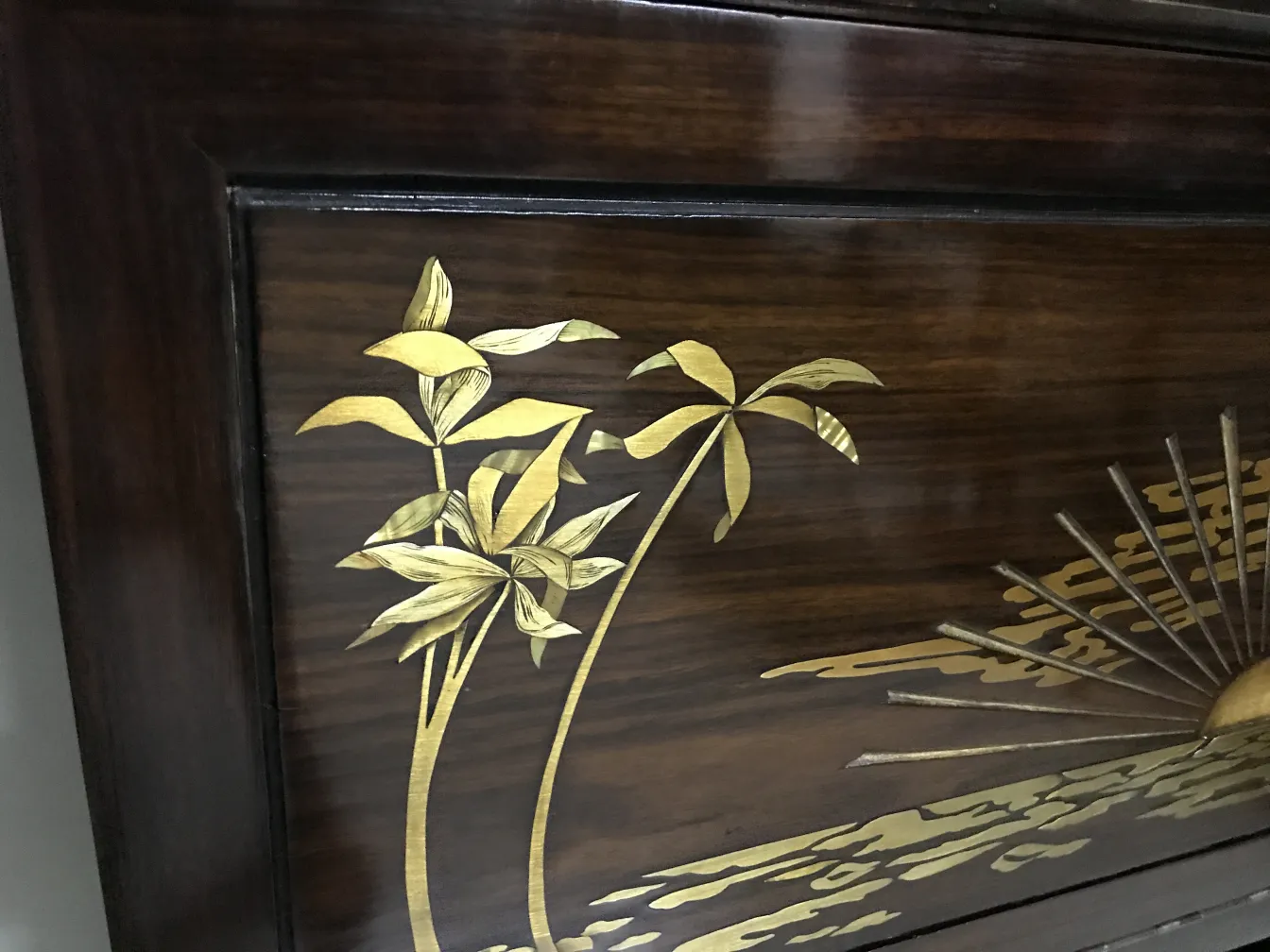 antike Vitrine mit goldenem Naturdesign, ergänzt durch Blätter und eine Sonne