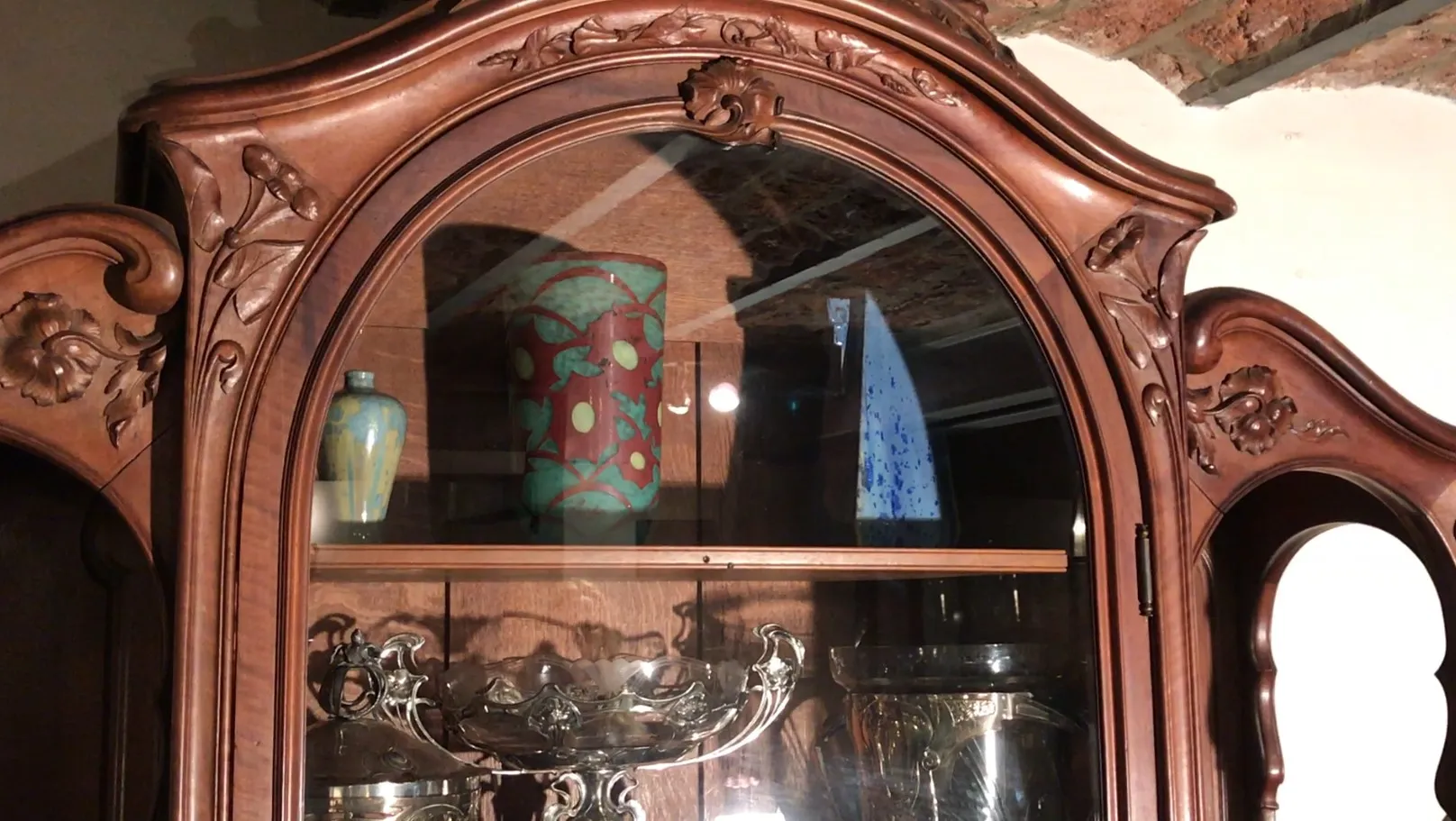 elegante vitrine antiga com detalhes decorativos e objetos de vidro