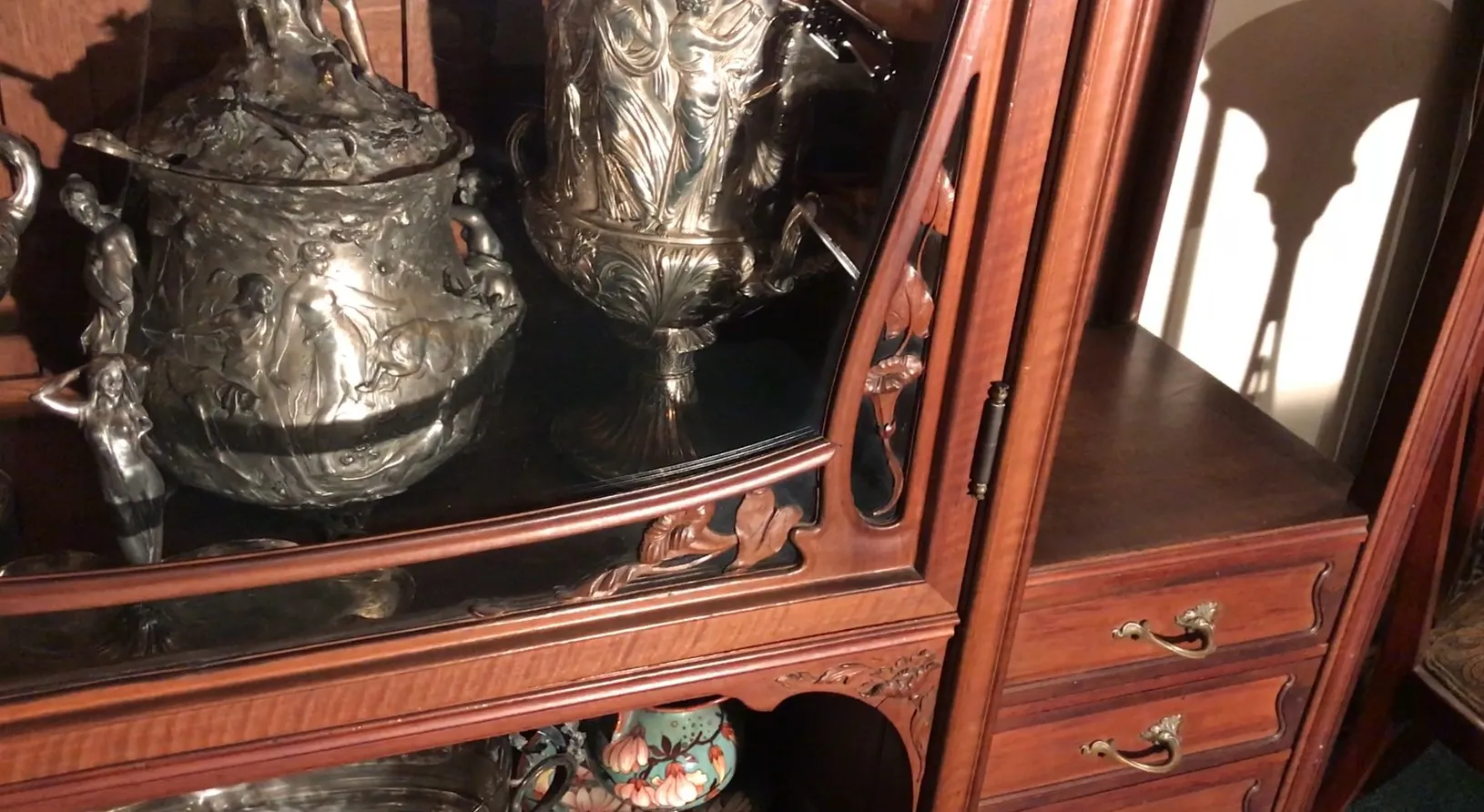 Vetrina antica con dettagli artistici e oggetti decorativi