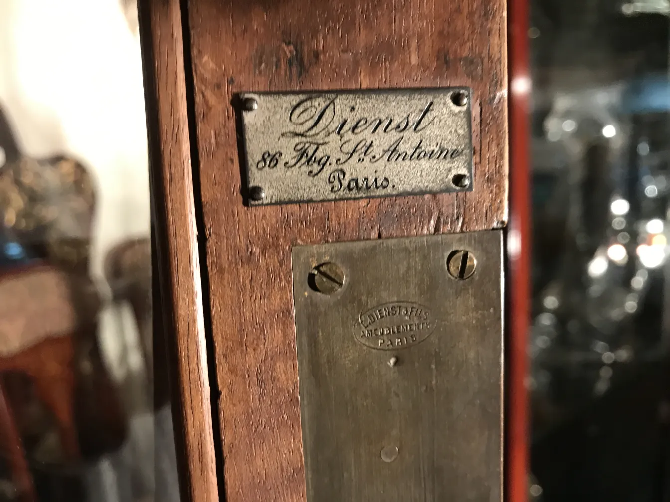 Vitrine antiga com placa de fabricante de Paris, ideal para exposição.