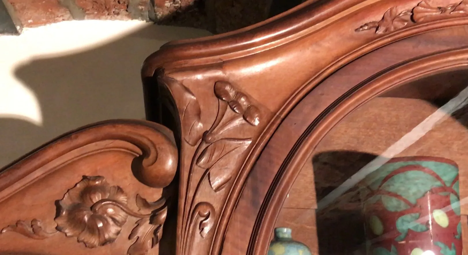 Vetrina antica con intricate sculture floreali e decorazioni.