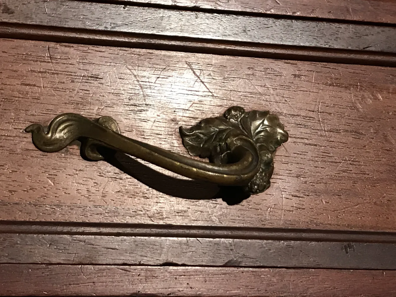 古董陈列柜把手的细节，上面有木制的叶子装饰