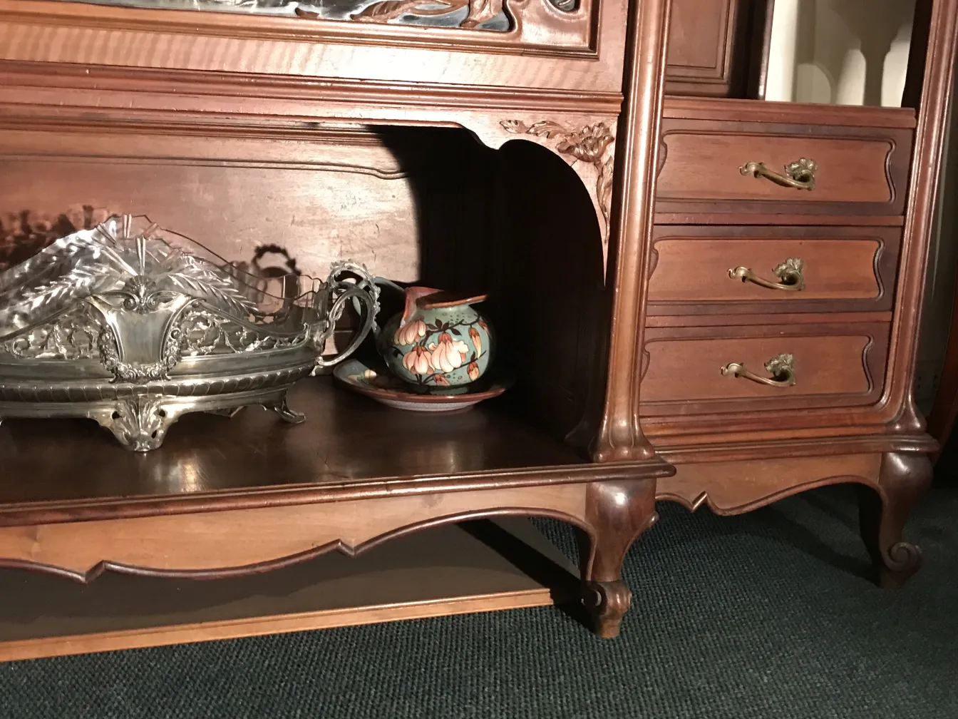 vetrina antica con forma elegante e decorazioni, oggetti in ceramica all'interno