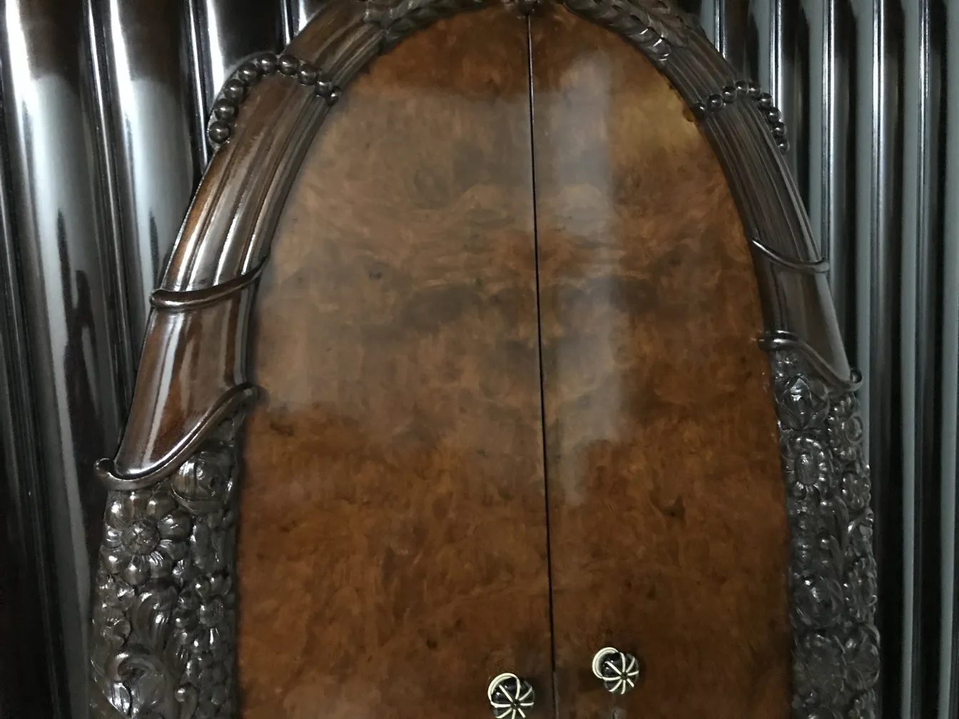 Antique display cabinet with ornate door and detailed carving.