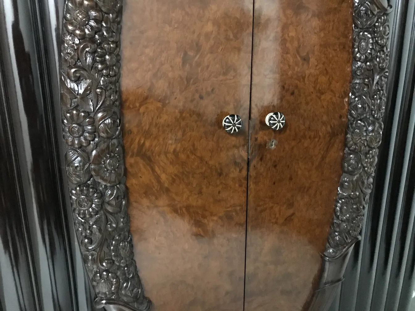 antique display cabinet with floral carvings and glossy finish