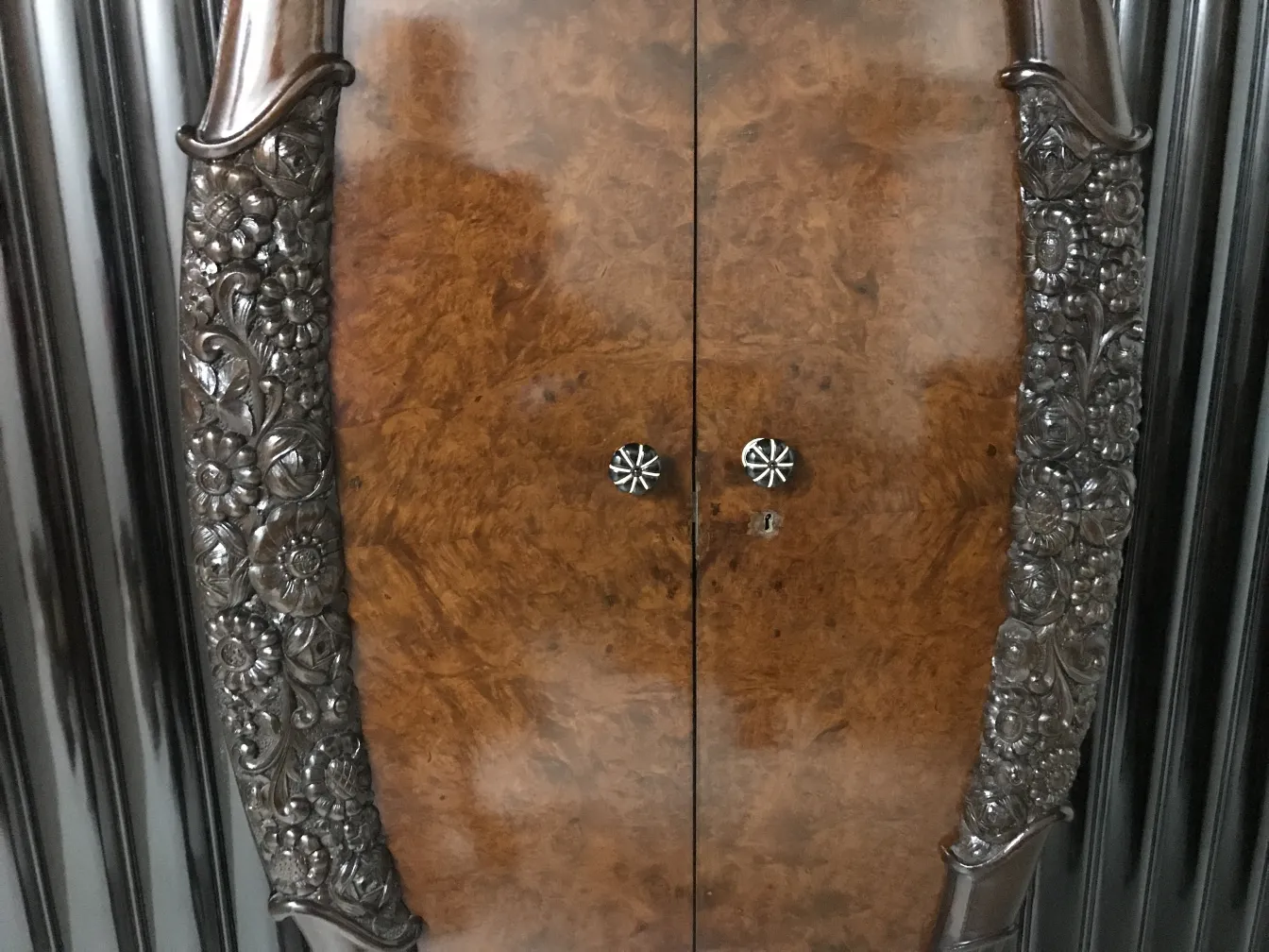 Antike Vitrine mit geschnitzten Details und dekorativen Oberflächen.