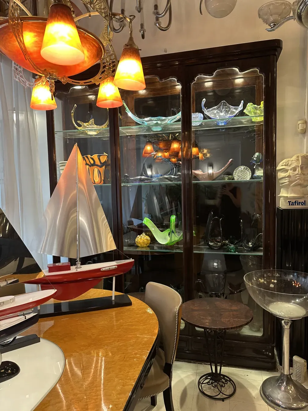 vitrina antigua iluminada con cristales de colores y objetos decorativos