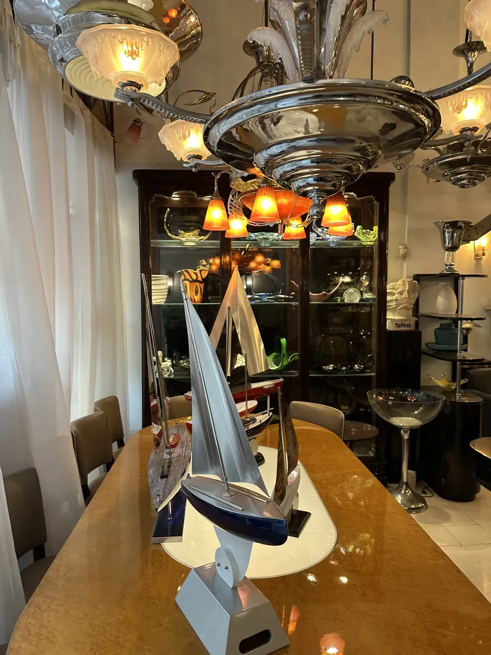 Vitrina antigua exhibiendo diversos objetos decorativos, junto a una mesa