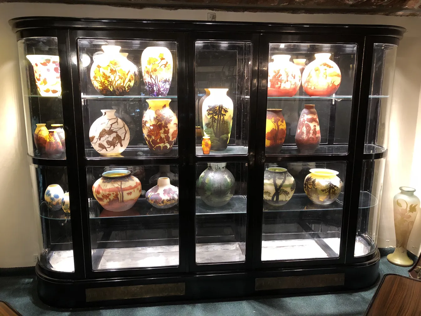 Vitrine antiga com itens decorativos e artísticos em destaque