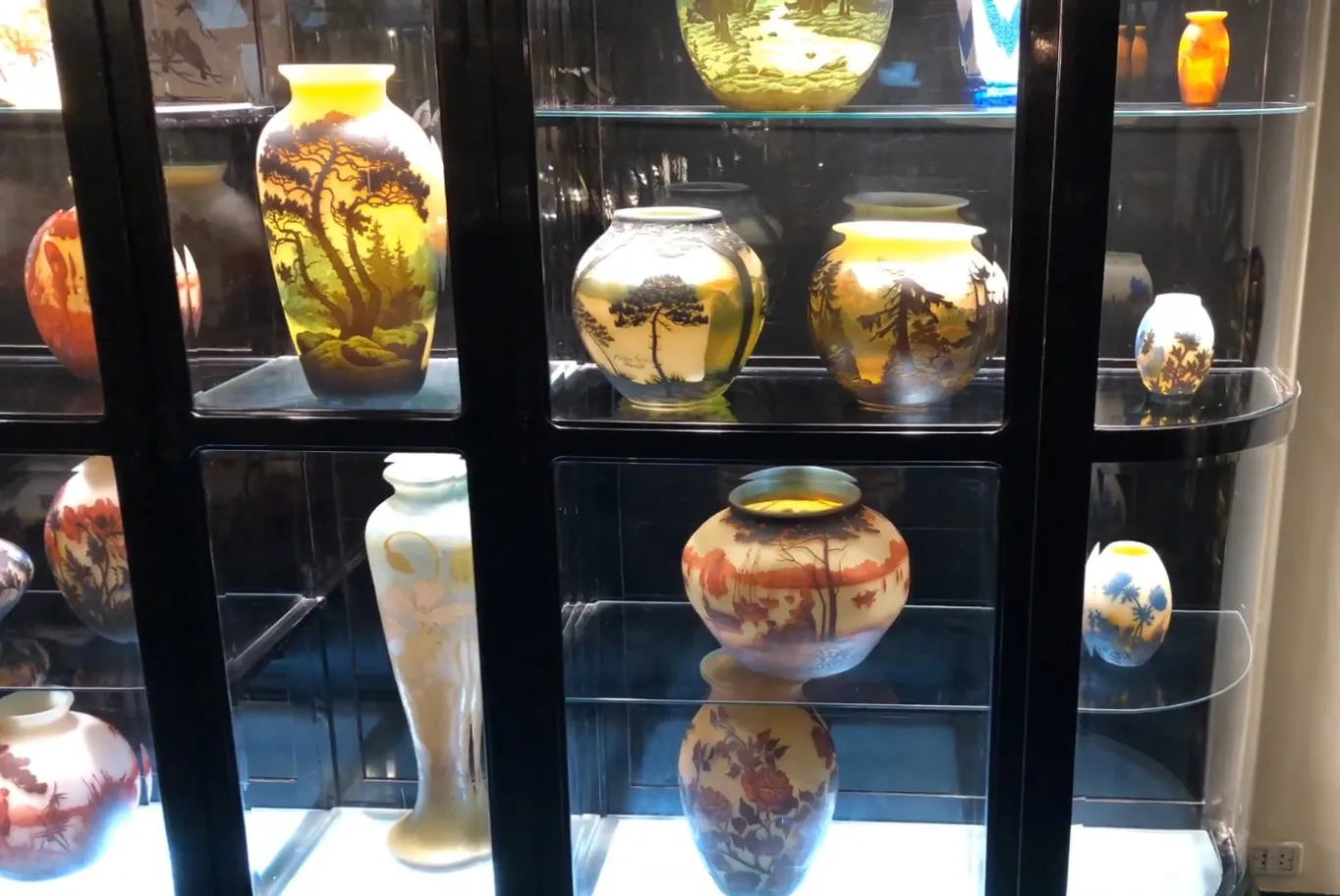 vitrine antique présentant divers vases décoratifs