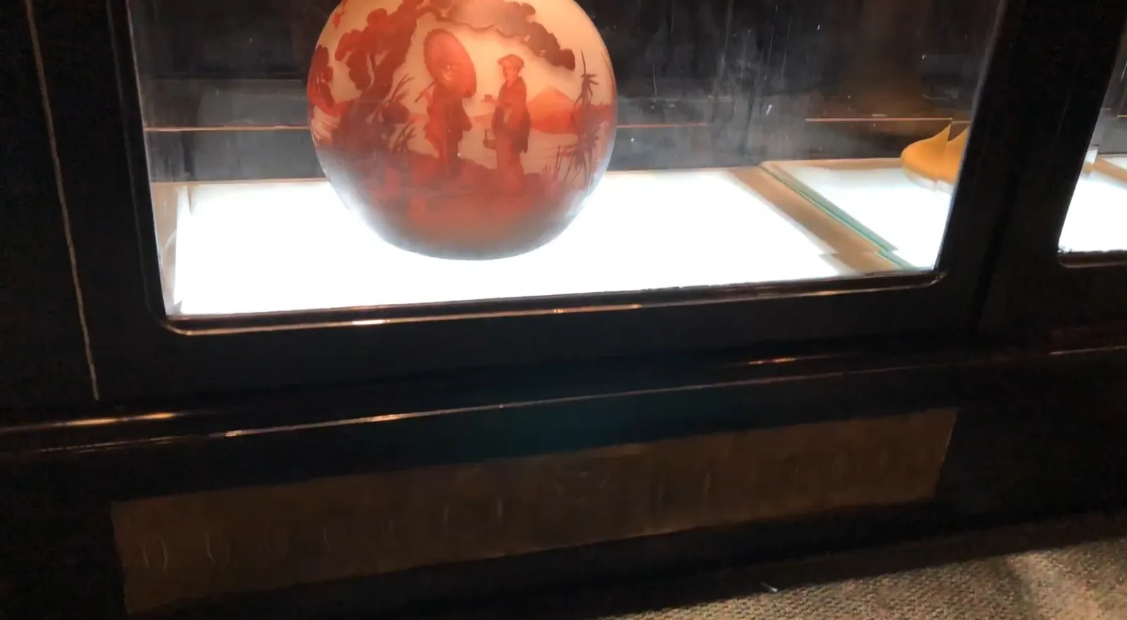 antique display cabinet featuring a decorative spherical object inside