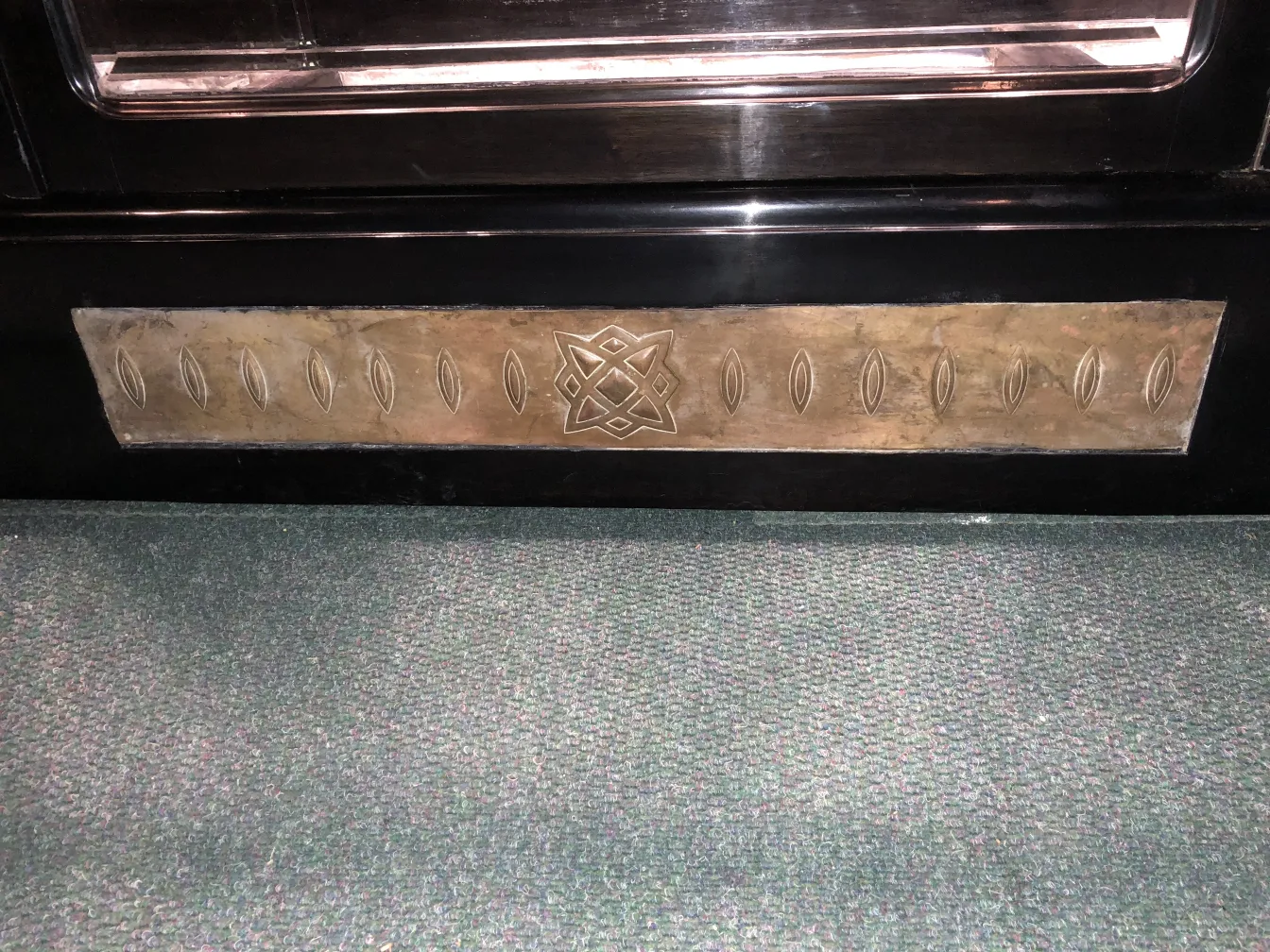 प्राचीन प्रदर्शनी कैबिनेट जिसमें सजावटी पैटर्न और गहरा पृष्ठभूमि है