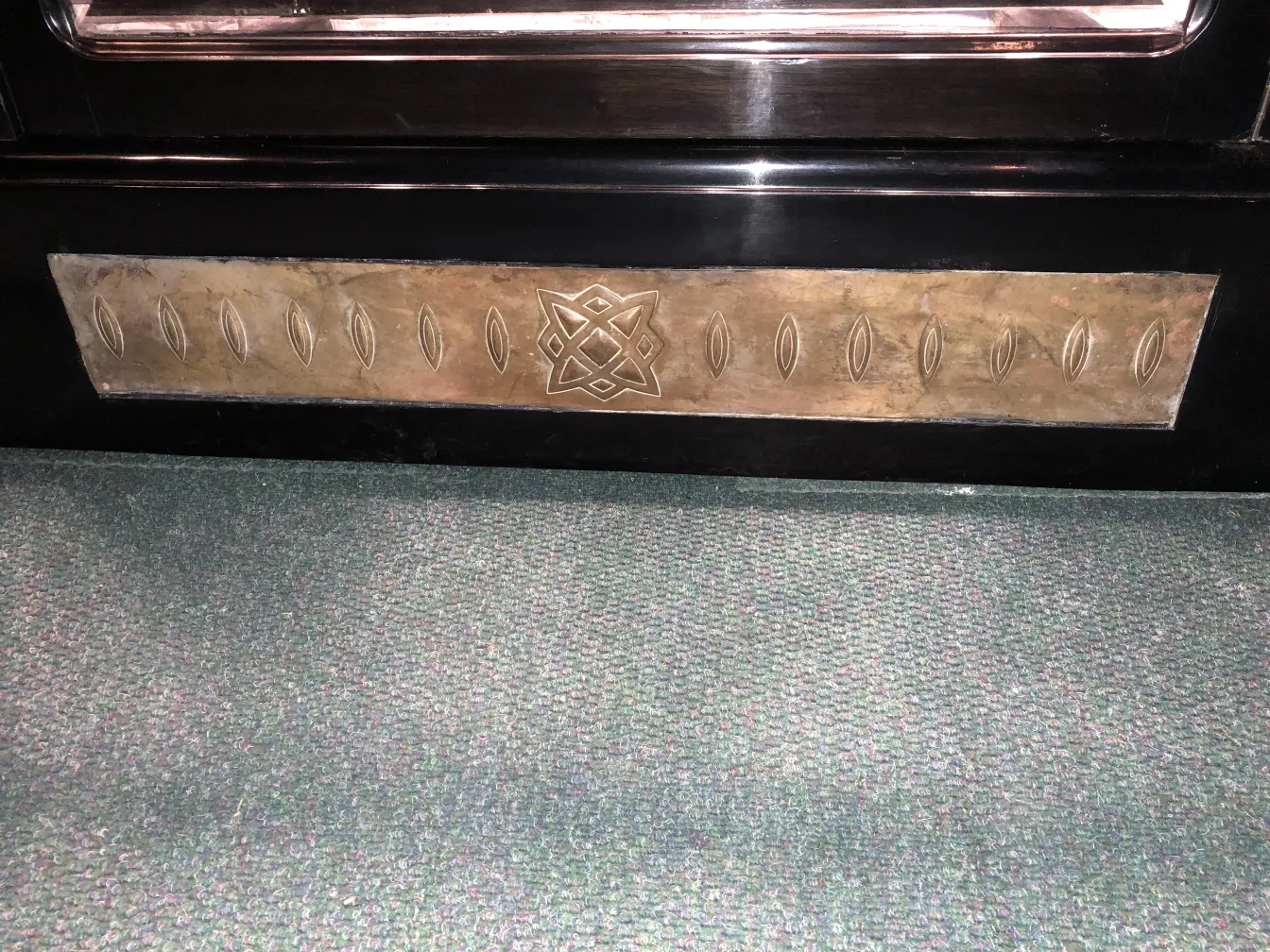 Antike vitrine, dekoriert mit ornamentalen Motiven und klassischem Stil, in einer gemütlichen Umgebung.