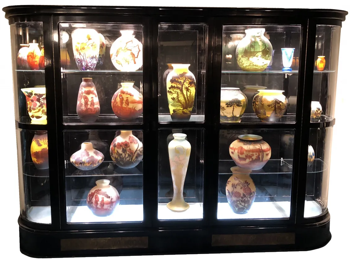 Antique display cabinet showcasing various decorative vases