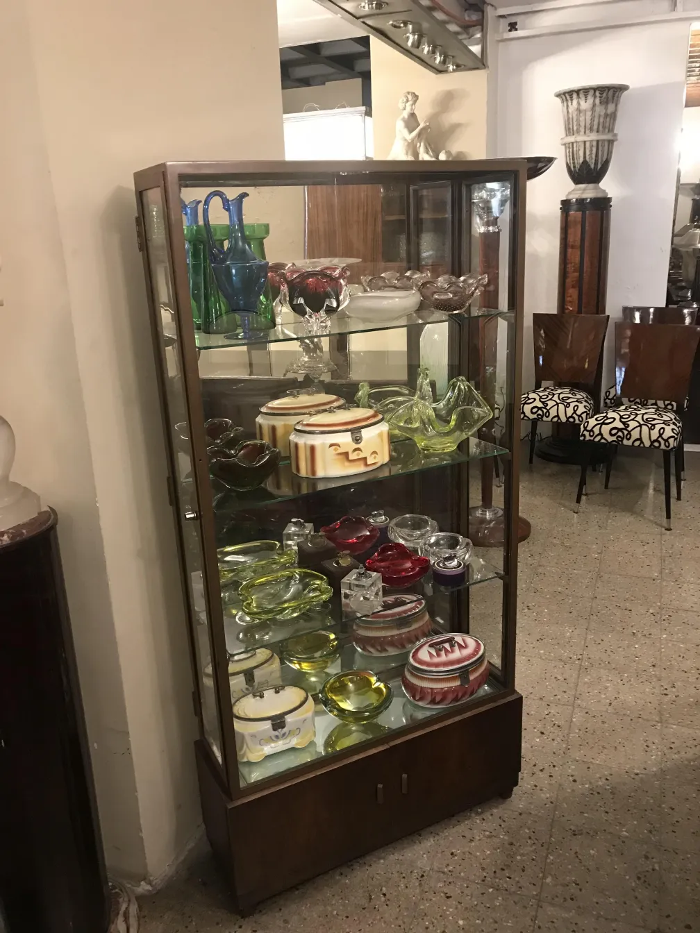 Vetrina antiquaria con oggetti decorativi in esposizione, stile classico.