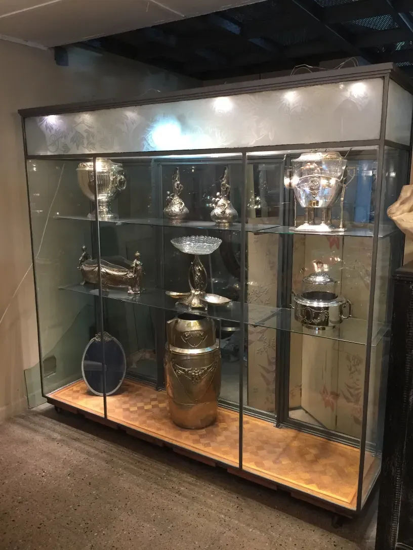 antique display cabinet showcasing shiny collectibles