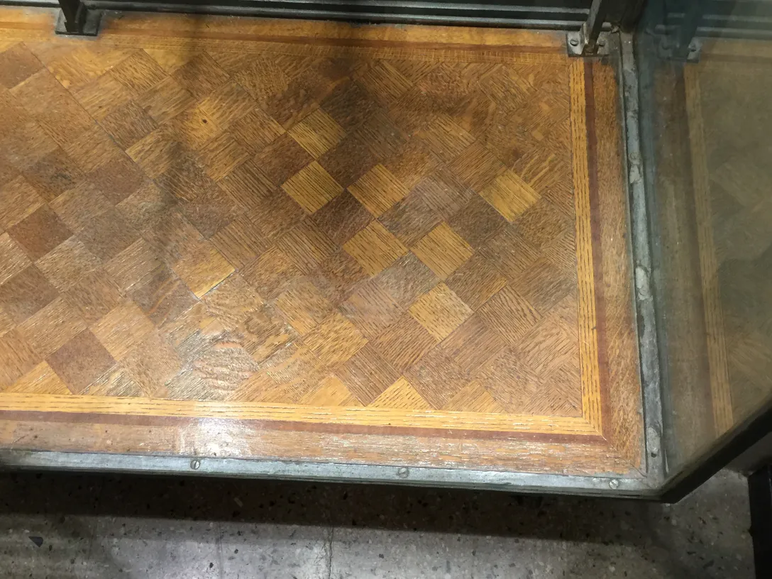 Antike Vitrine mit zweifarbigen Mustern auf dem Boden, die eine antike Atmosphäre zeigen.