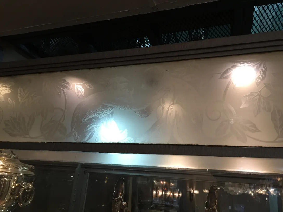 vitrine antiga com design floral na parte superior iluminada