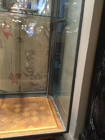 vitrine antiga com fundo espelhado e detalhes em madeira