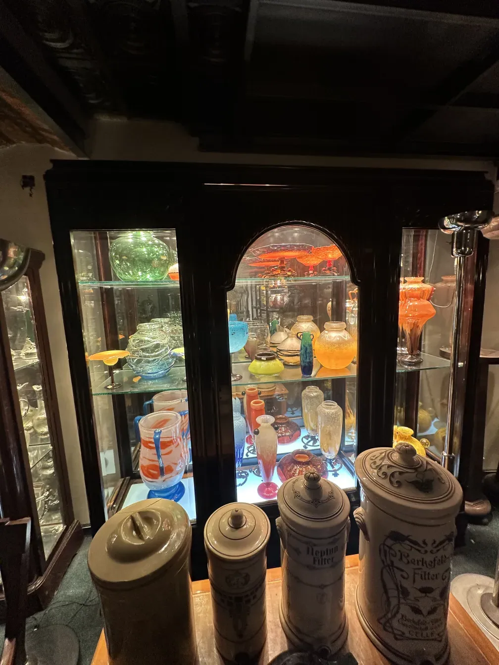 vitrine ancienne avec des objets en verre colorés
