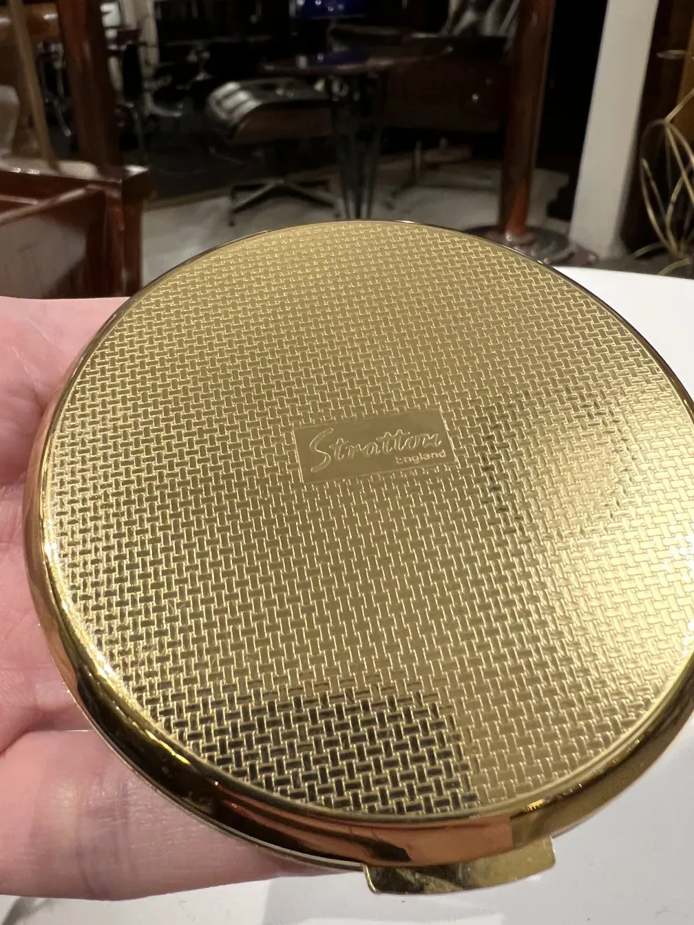 Compatto dorato antico con texture in rete e logo