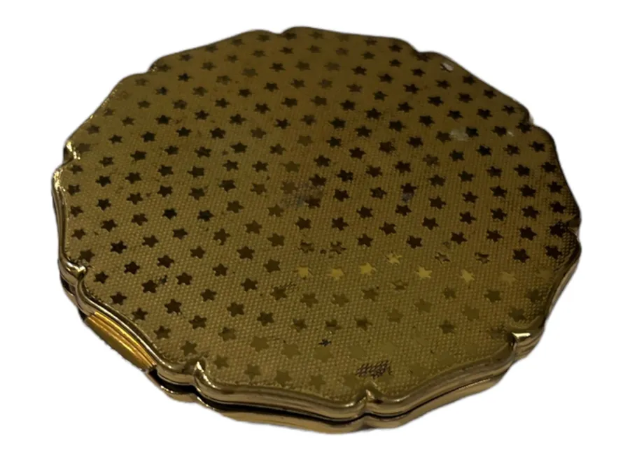 Antique golden compact with decorative stars