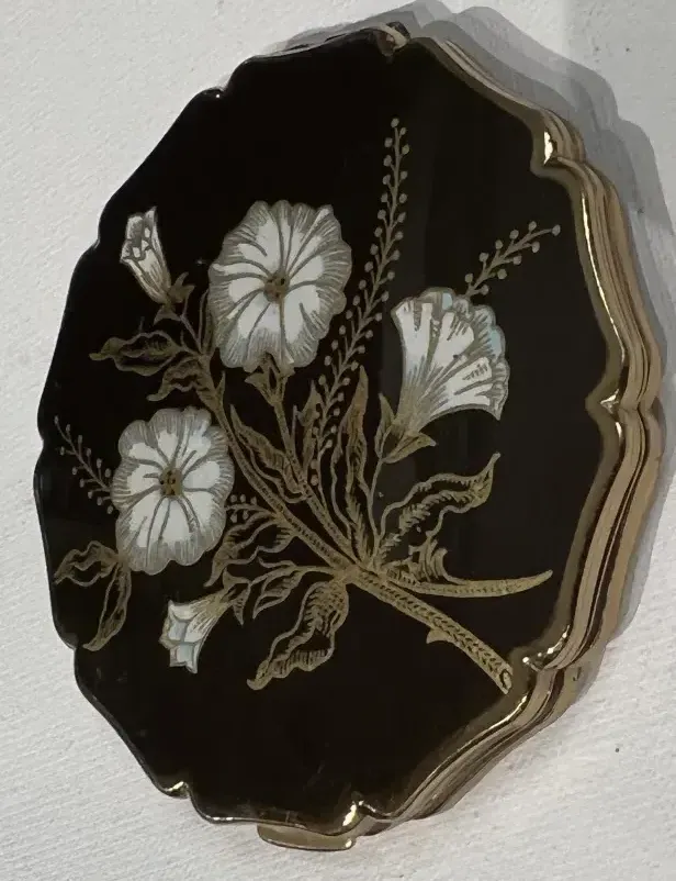 Stratton England compact with white flowers on black background