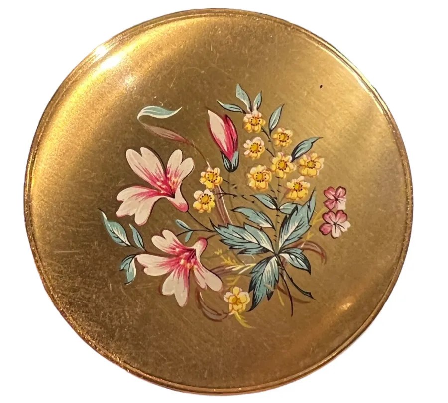 round antique compact with pink and yellow floral design