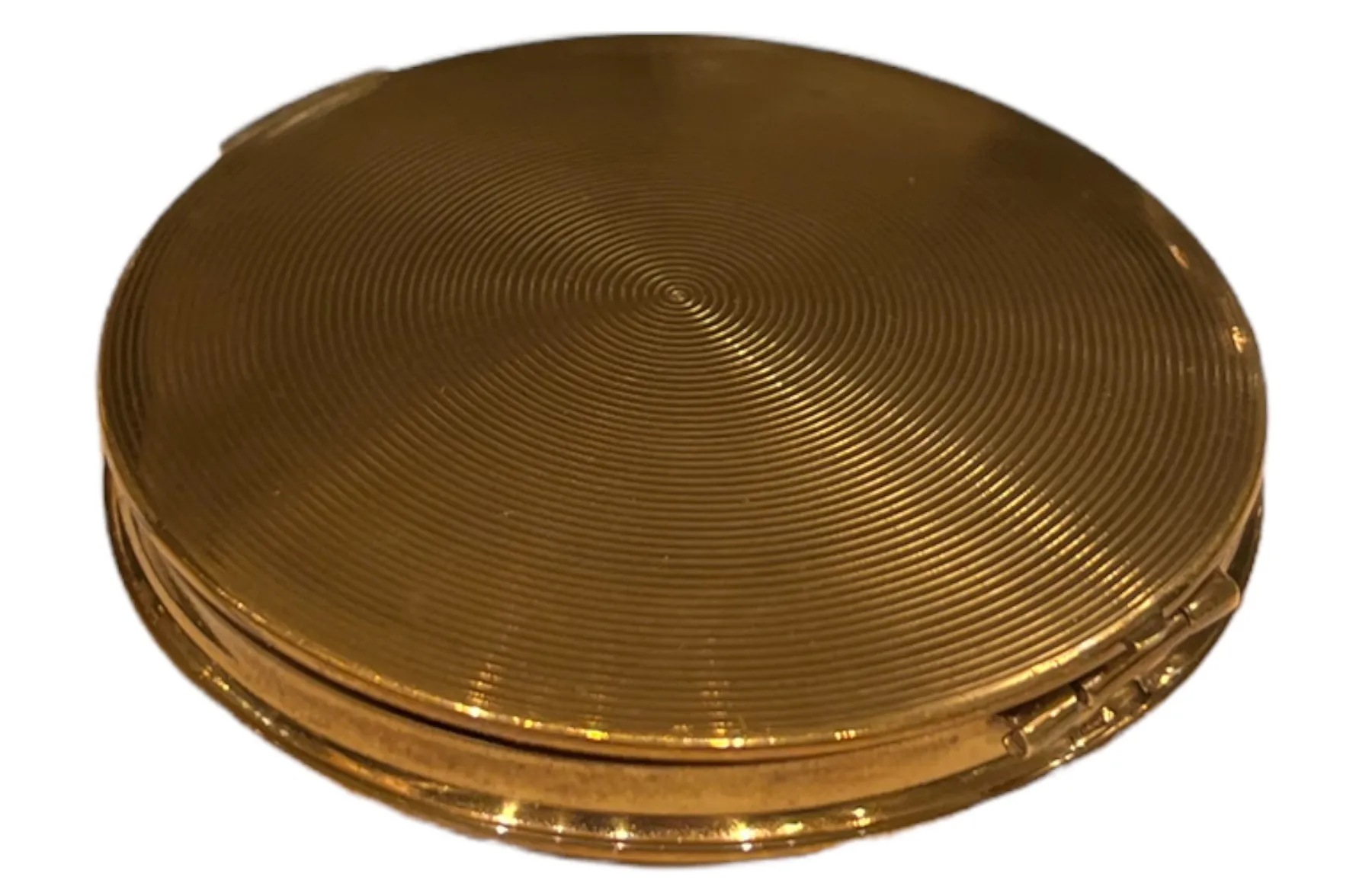 Polvera antigua con diseño circular y superficie brillante en oro