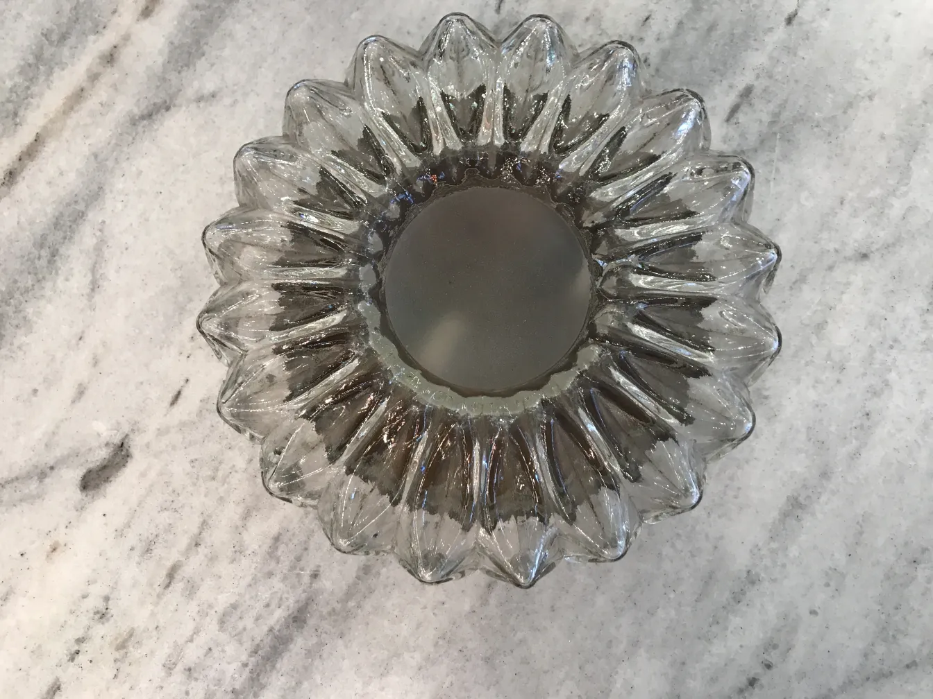 plafon antigo com formato de flor e acabamento brilhante em um ambiente neutro