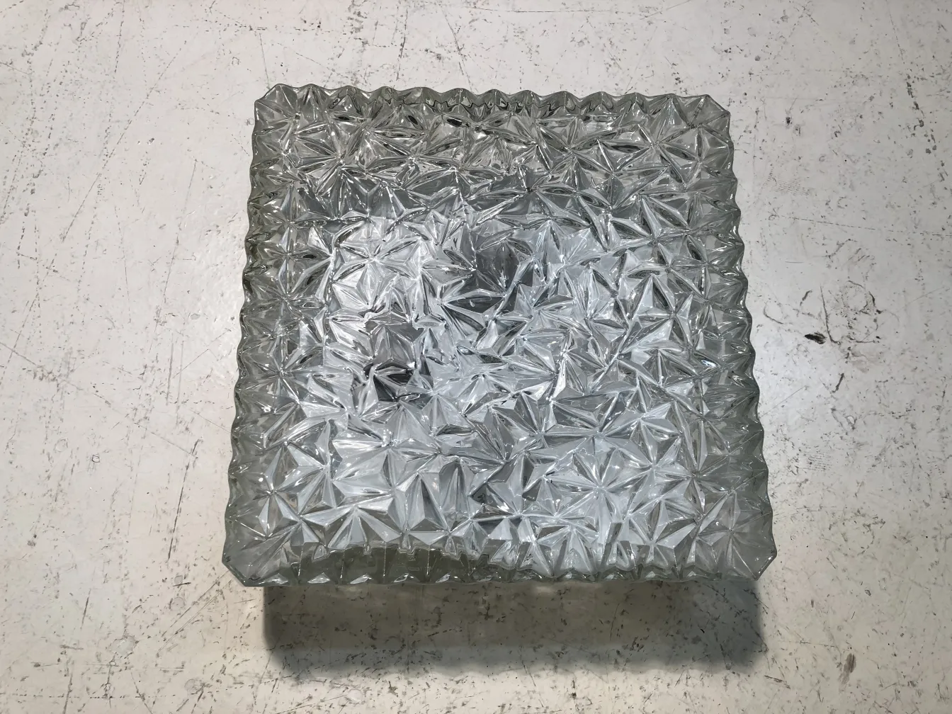 plafon antiguo de vidrio con diseño decorativo, con figura en relieve, sobre una superficie blanca