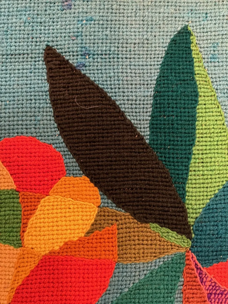 antiker Wandteppich mit bunten Designelementen auf blauem Hintergrund