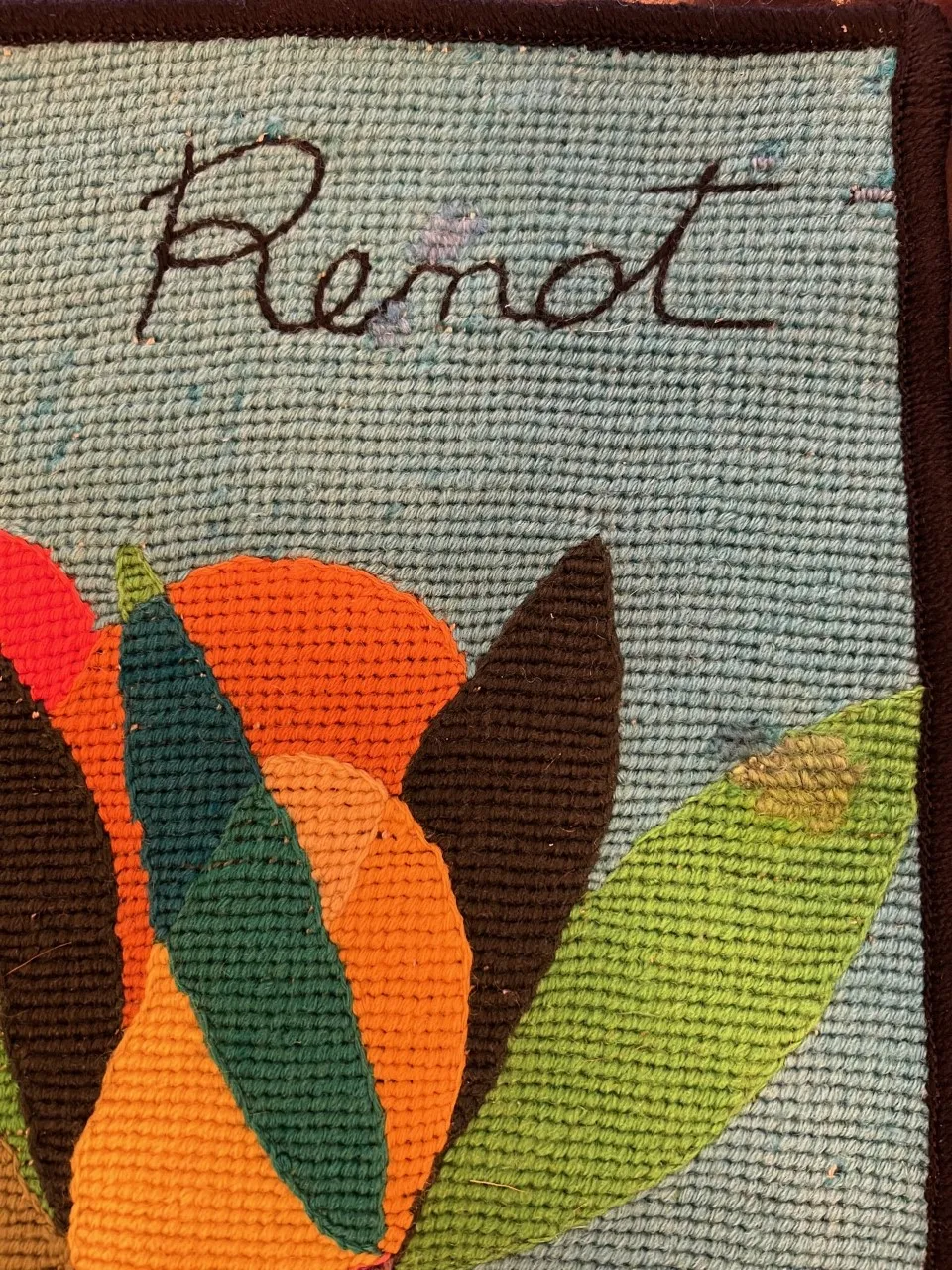 tapiz antiguo con flores brillantes en varios colores sobre fondo azul