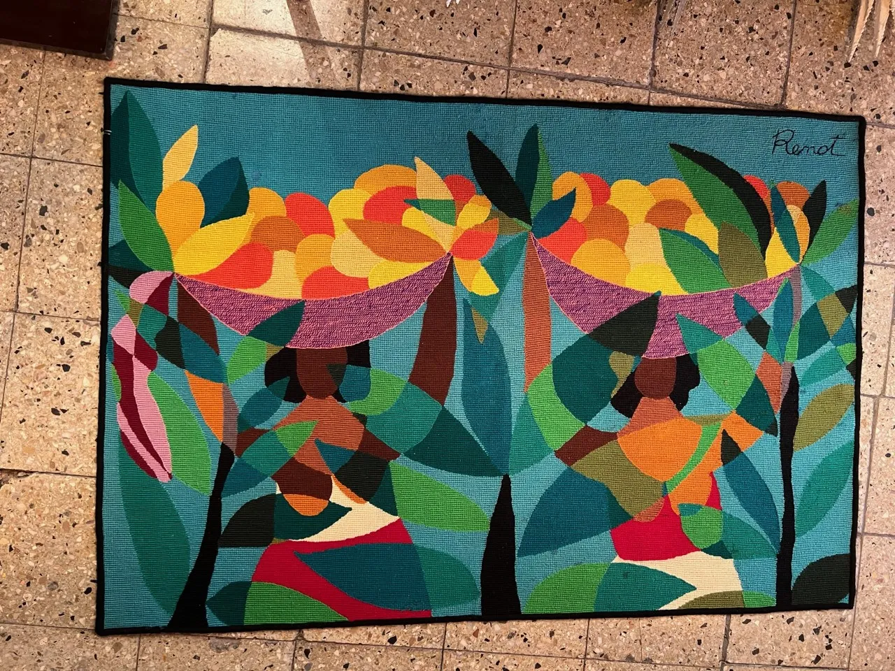 tapiz antiguo con colores vibrantes y formas geométricas en un entorno neutro