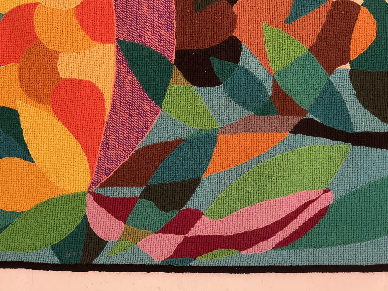 antique tapestry featuring leaf design in warm and cool tones