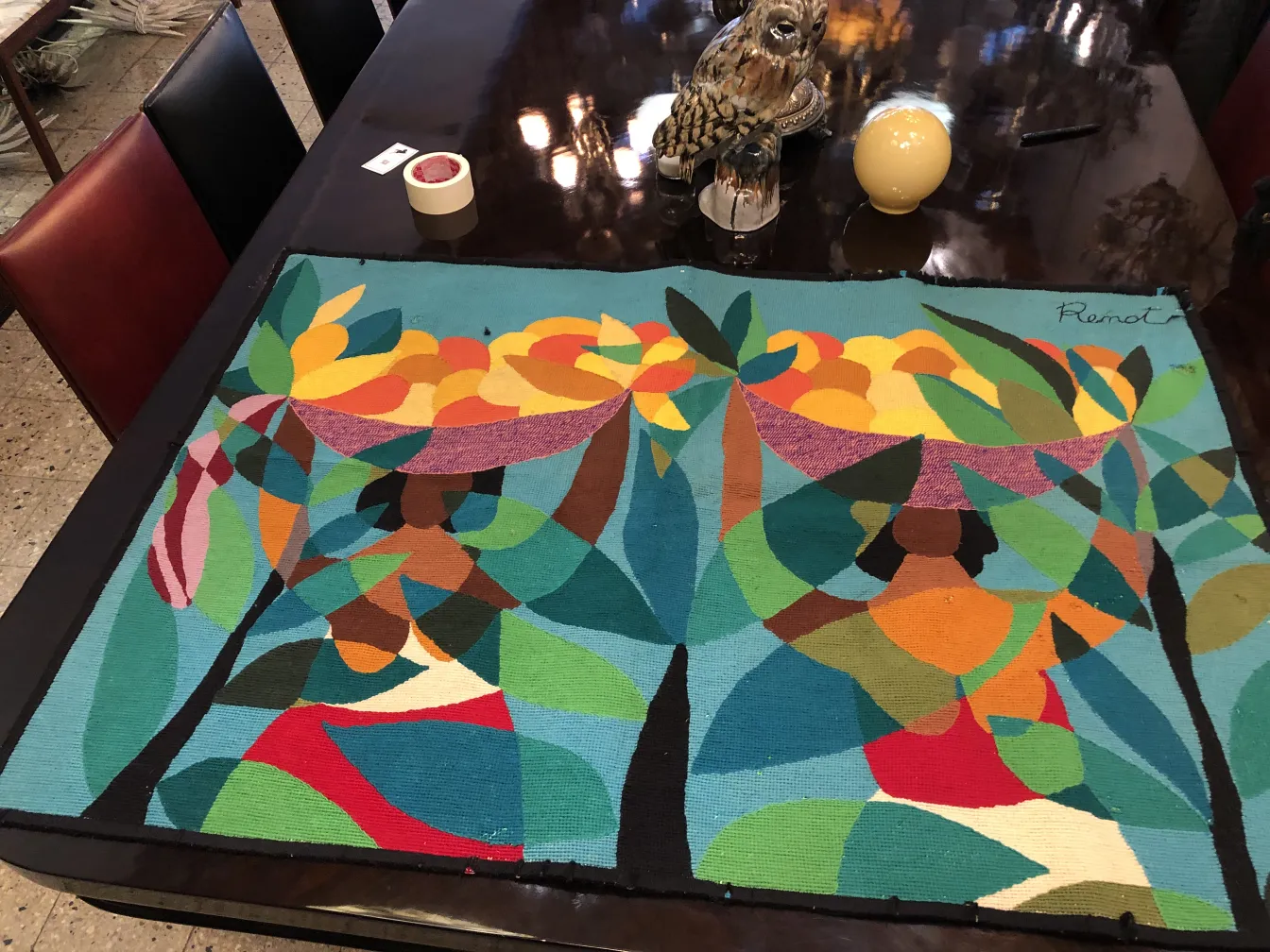 Tapeçaria antiga com frutas coloridas e folhas em fundo azul.