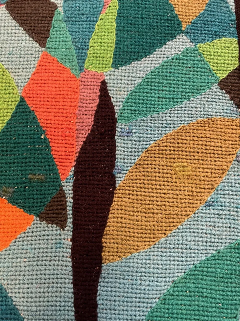 arazzo antico con texture spessa, colori vivaci e motivi a forma di foglia