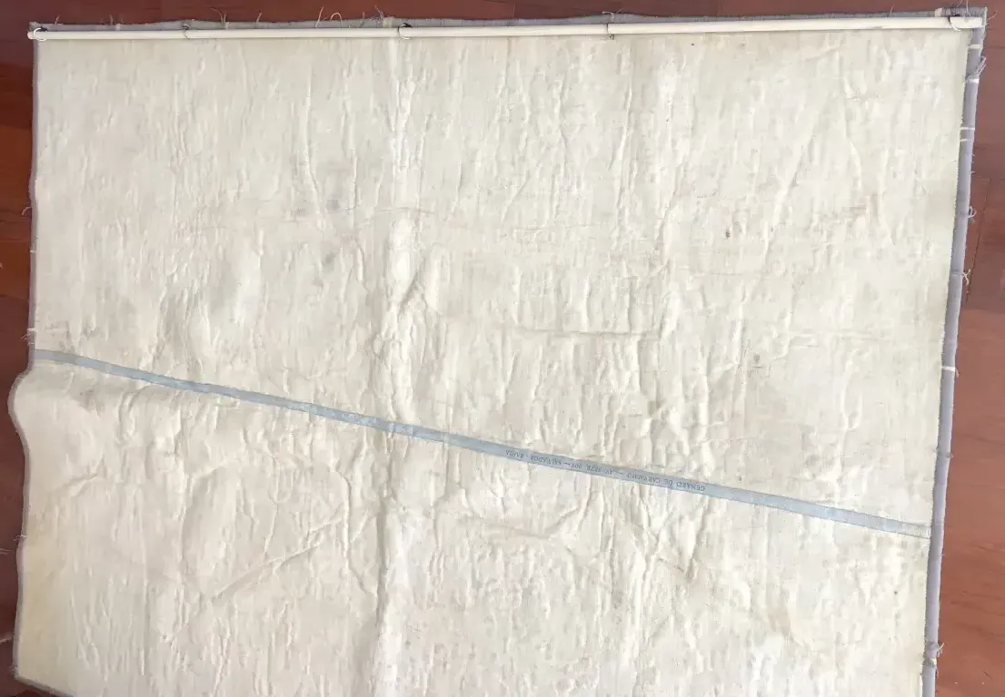 Tappeto antico con morbida texture e colore chiaro, opera di Genaro de Carvalho, su sfondo neutro.