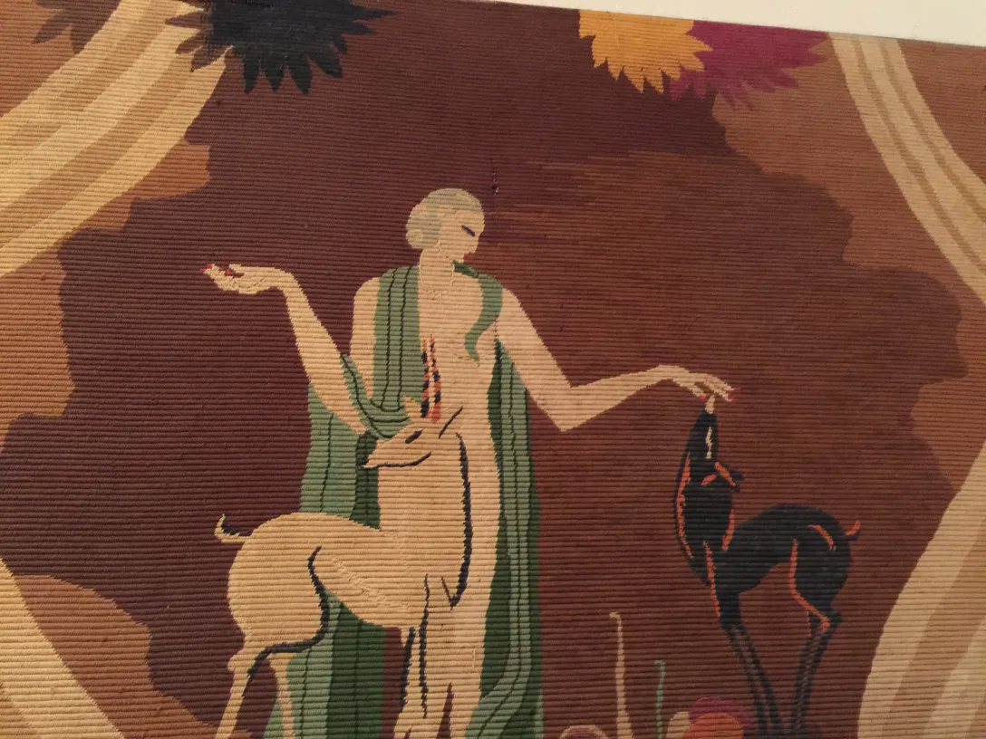 tapiz antiguo con figura humana y ciervo, fondo cálido