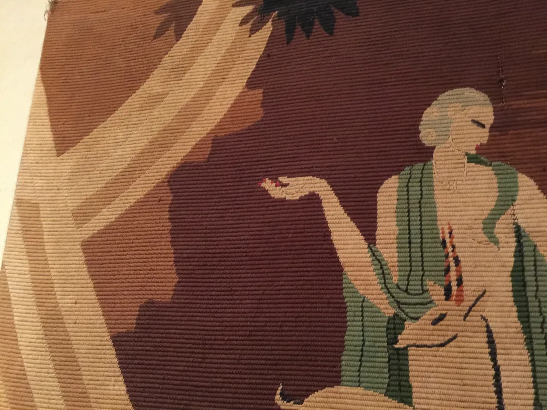 tapiz antiguo con representación artística y detalles coloridos en tonos suaves, incluye figura humana y fauna