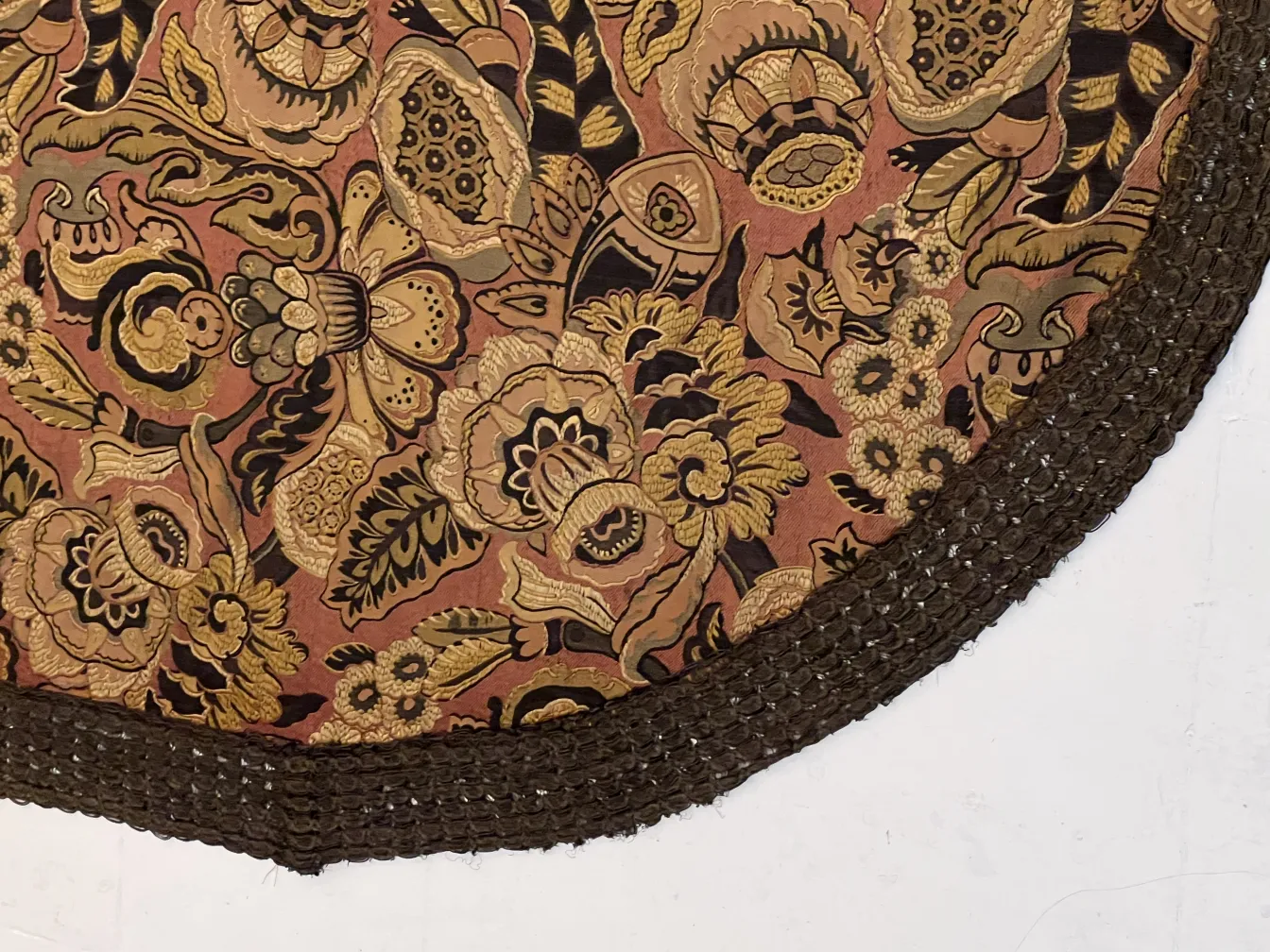 mantel antiguo con un diseño floral colorido en tonos cálidos